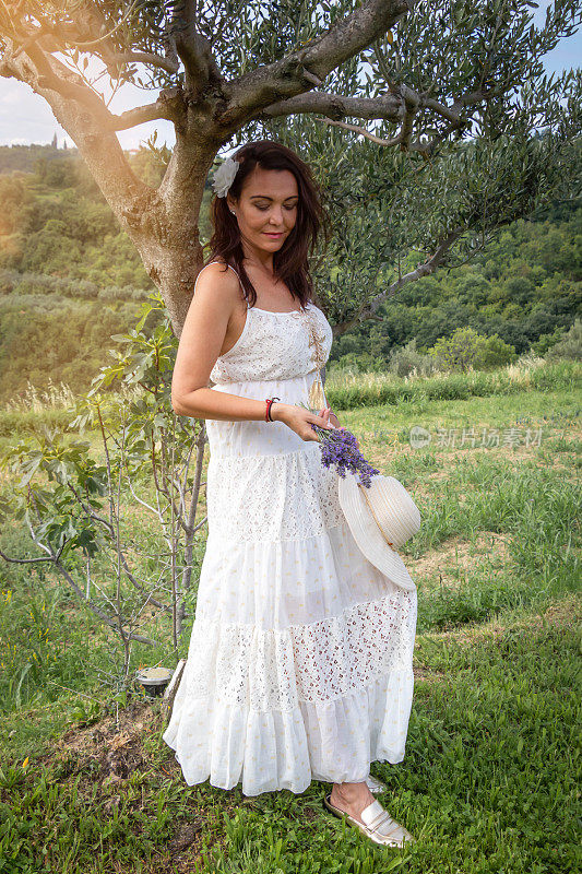 Woman leaning on the olive tree